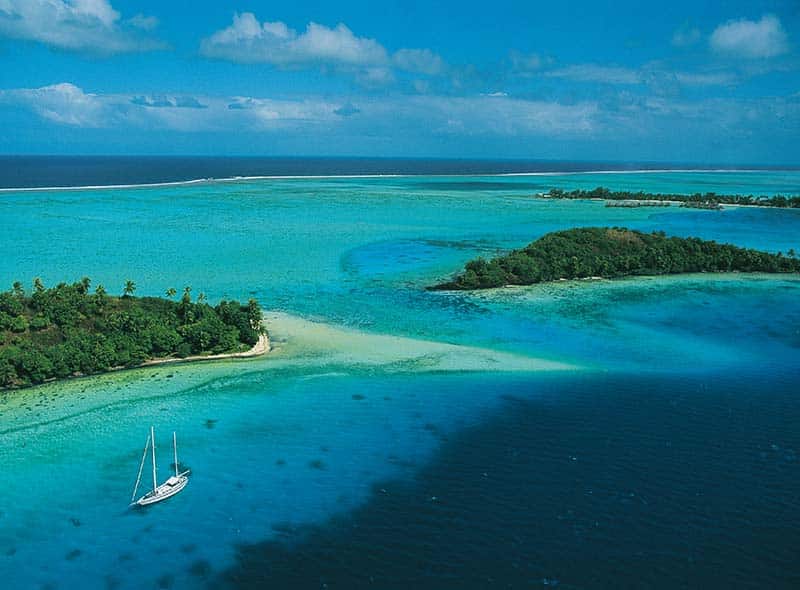 En seilbåt i lagunen Bora Bora og Huahine i Fransk Polynesia