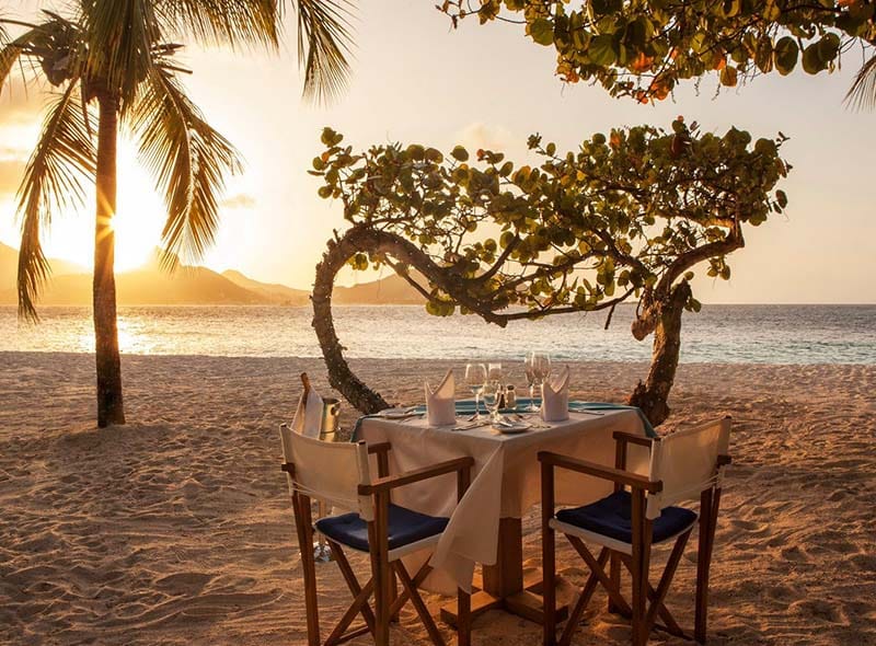 Et bord er dekket for en romantisk middag for to på stranda