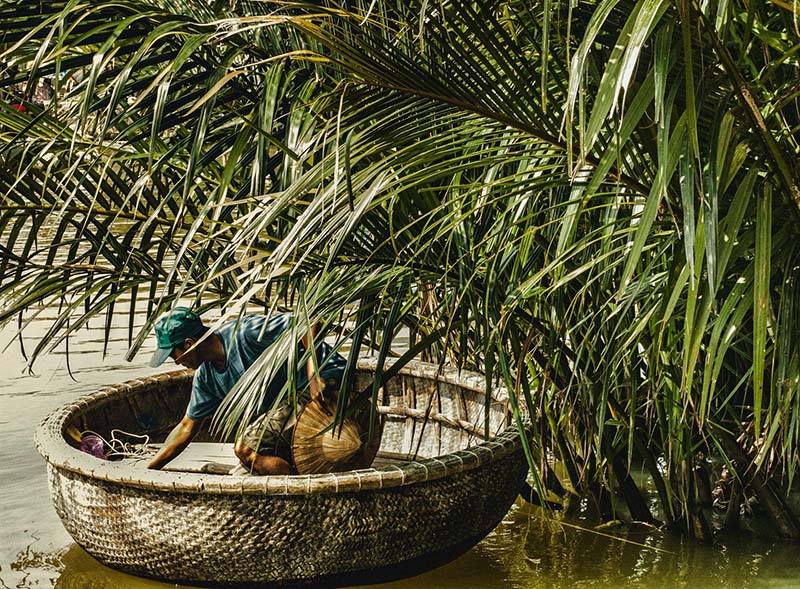 En person i en liten rund båt laget av bambus