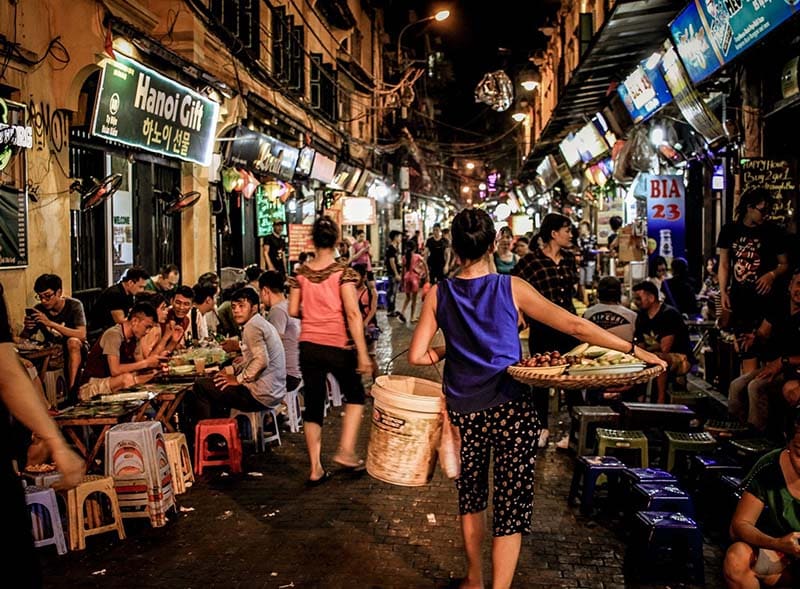 En bakgate i Hanoi på kvelden hvor folk spiser utendørs