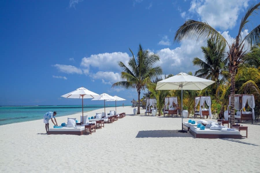 Flotte solsenger og parasoller på en nydelig sandstrand. Femstjerners hotell Dinarobin Mauritius