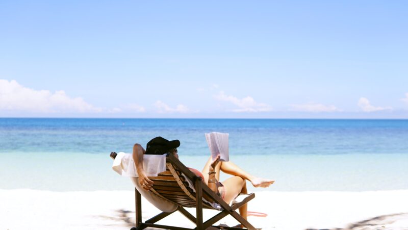 En dame slapper av på stranda på ferie.