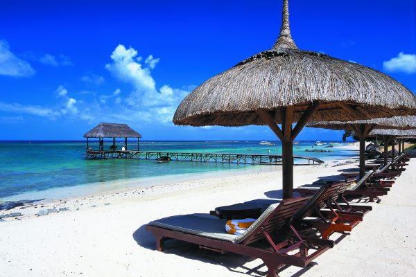 The Oberoi Mauritius strand med solstoler og parasol.